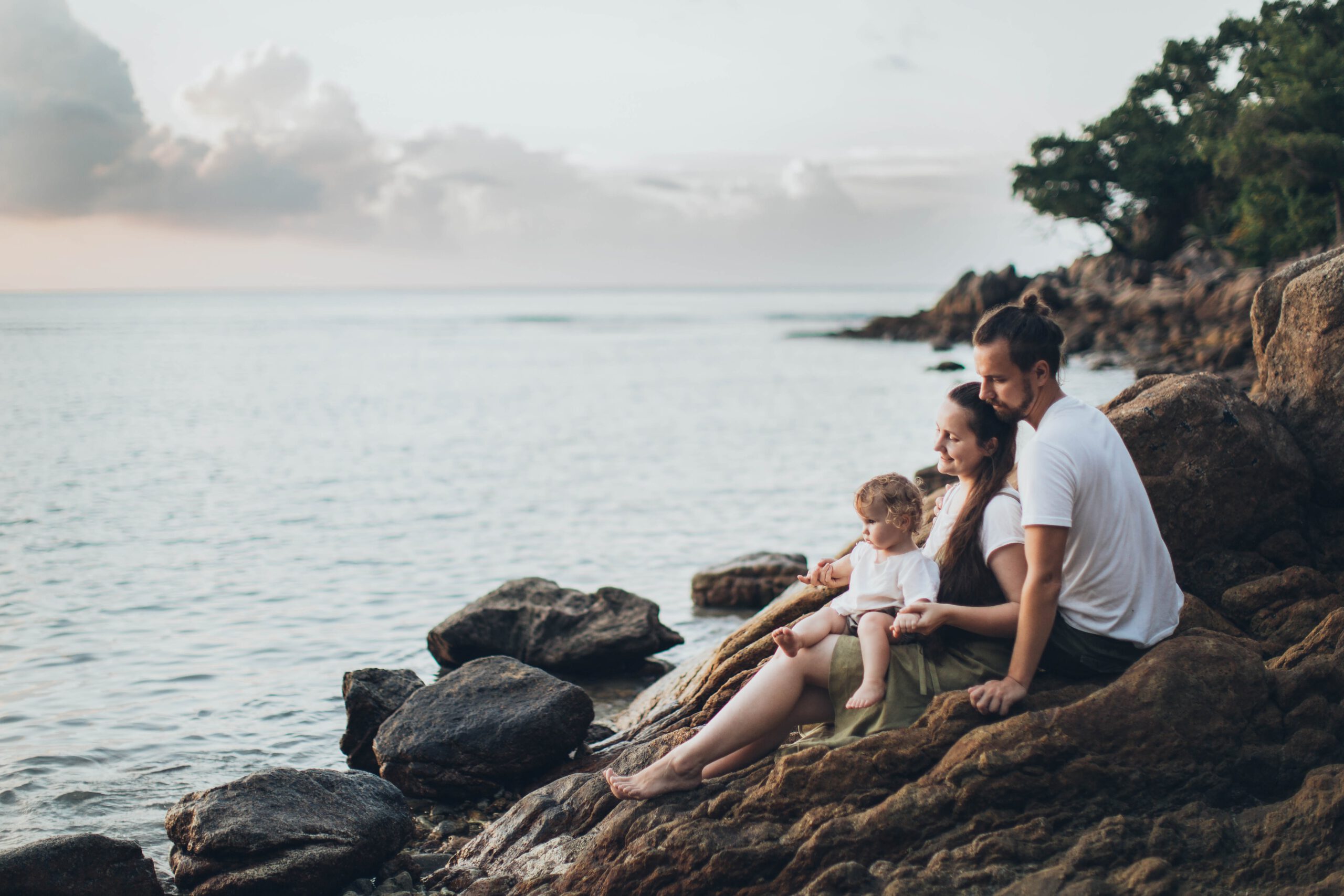 man-and-woman-sitting-on-rock-near-seashore-1914982